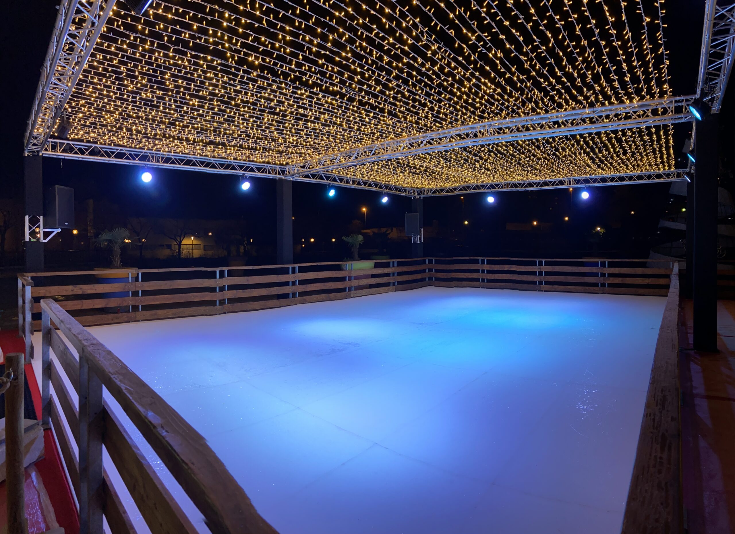 Patinoire sous un plafond de guirlandes lumineuses dorées