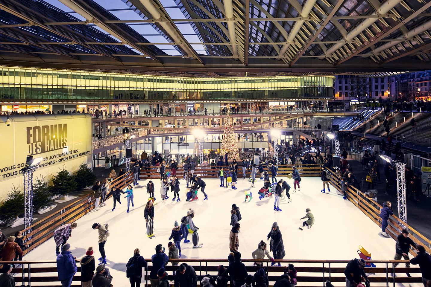 Nombreux patineurs sur une grande patinoire synthétique sous la halle du Forum des Halles